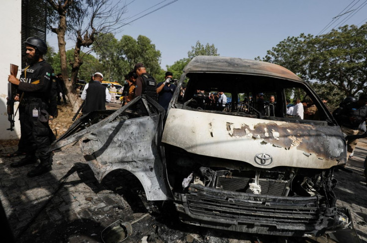 Police officers and members of the investigation team gather near a passenger van, after a blast at the entrance of the Confucius Institute University of Karachi, Pakistan April 26, 2022.