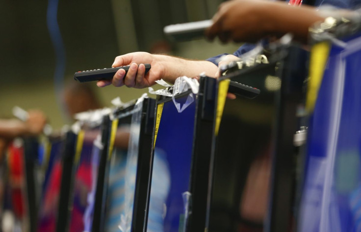 Workers use remote controls to check television sets before they are repackaged at Element Electronics in Winnsboro, South Carolina May 29, 2014.  