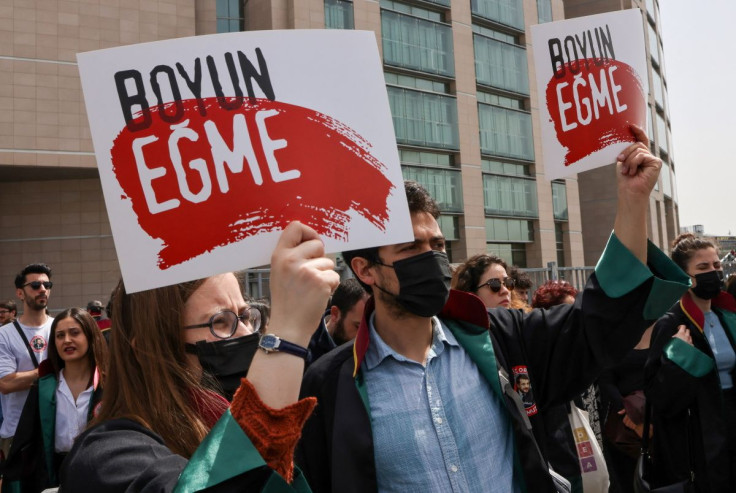 Lawyers hold banners reading "Don't bow down" as they take part in a protest against a Turkish court decision that sentenced philanthropist Osman Kavala to life in prison over trying to overthrow the government, in front of Caglayan Courthouse, in Istanbu