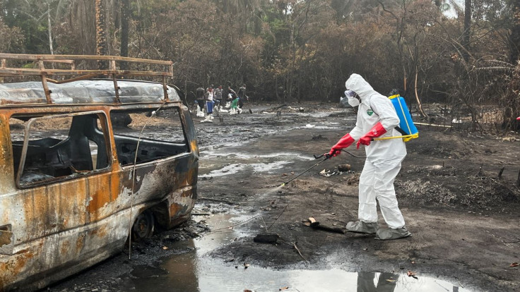 A health worker sprays the scene of the explosion at the illegal bunkering scene in Imo State, Nigeria April 26, 2022. 