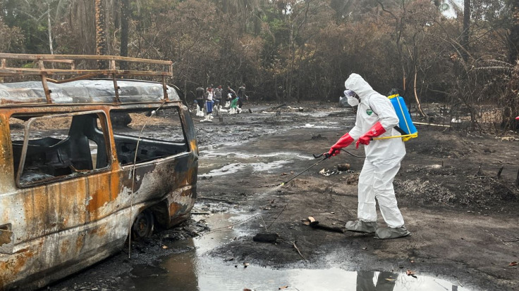 A health worker sprays the scene of the explosion at the illegal bunkering scene in Imo State, Nigeria April 26, 2022.