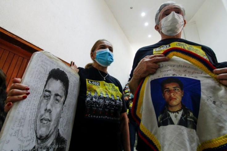 Relatives of a victim hold posters with his portrait during a hearing organized by the Special Jurisdiction for Peace (JEP) in Ocana, Colombia, on April 26, 2022