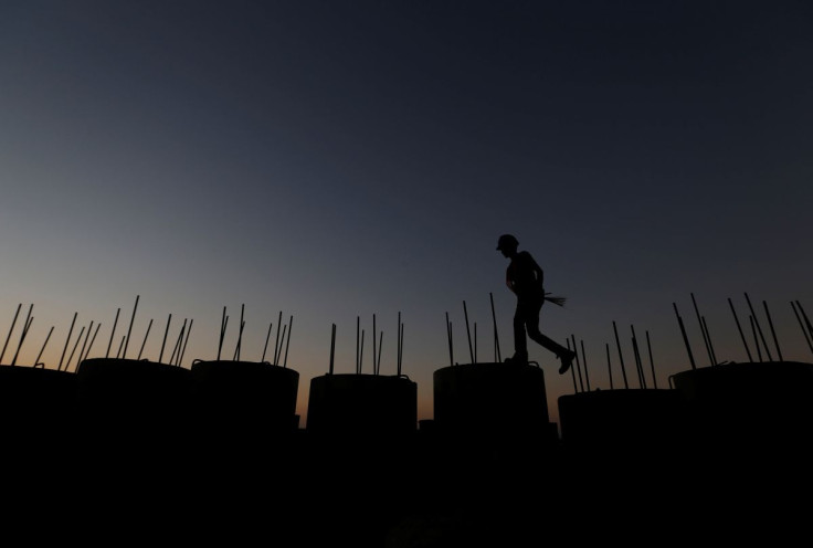 A worker walks on top of seawall concrete at the New Priok Port in Jakarta, Indonesia July 26, 2017.