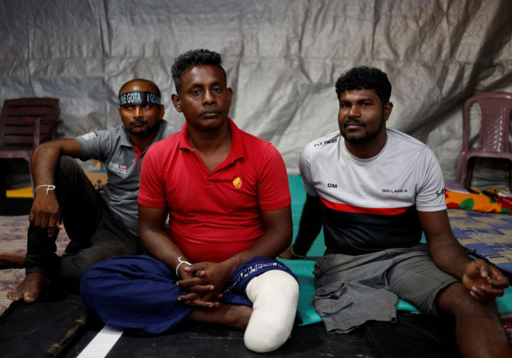 Sri Lankan military veterans H.M.S Mahindasiri, (C) and Uditha Roshan (R) sit at a protest site near the Presidential Secretariat in Colombo, Sri Lanka, April 25, 2022. Picture taken April 25, 2022.