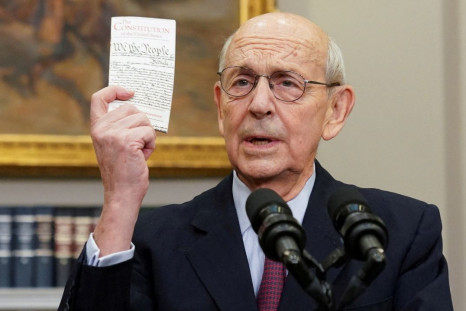 U.S. Supreme Court Justice Stephen Breyer holds up a copy of the U.S. Constitution as he announces he will retire at the end of the court's current term, at the White House in Washington, U.S., January 27, 2022. 