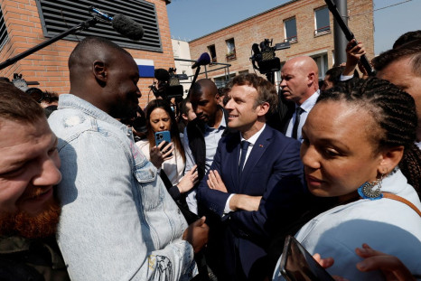 French President Emmanuel Macron talks with residents during a walkabout at the Saint-Christophe market square in Cergy, Paris suburb, as part of his first trip after being re-elected president, France, April 27, 2022. 