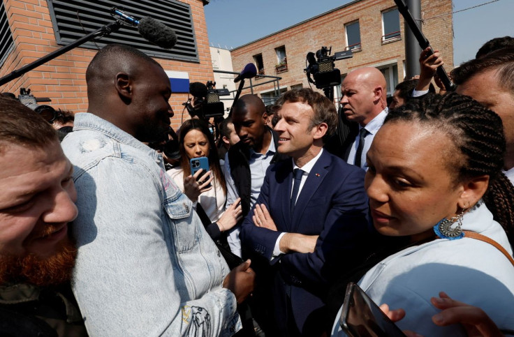 French President Emmanuel Macron talks with residents during a walkabout at the Saint-Christophe market square in Cergy, Paris suburb, as part of his first trip after being re-elected president, France, April 27, 2022. 