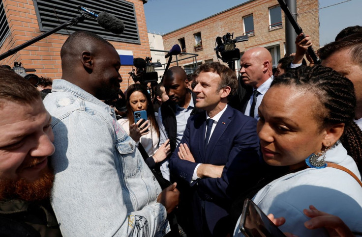French President Emmanuel Macron talks with residents during a walkabout at the Saint-Christophe market square in Cergy, Paris suburb, as part of his first trip after being re-elected president, France, April 27, 2022.