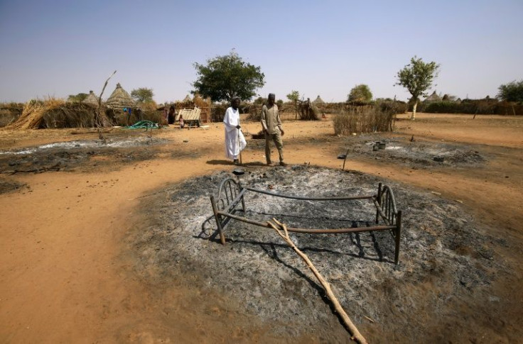 Sudanese check the aftermath of violence in South Darfur in February 2021