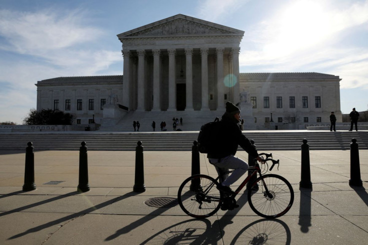 A cyclist rides in front of the U.S. Supreme Court building in Washington, U.S. March 15, 2022. 