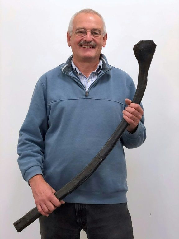 Professor Martin Sander posing with a rib from an estimated 20 meters long ichthyosaur