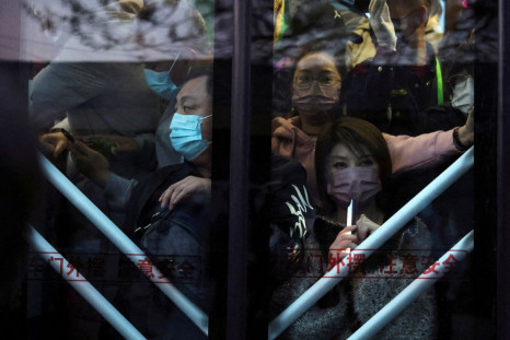 Commuters wearing face masks following the coronavirus disease (COVID-19) outbreak stand on a bus in the early morning, near a border checkpoint with Hebei province, in Beijing, China April 13, 2022. Picture taken April 13, 2022. 