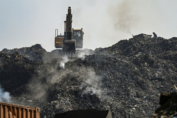 A burning rubbish dump choked Delhi residents for a third day, with firefighting teams battling the blaze with lorry-loads of sand and mud