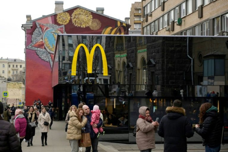 People take pictures in front of the McDonald's flagship restaurant at Pushkinskaya Square - the first one of the chain opened in the USSR on January 31, 1990 - in central Moscow on March 13, 2022, McDonald's last day in Russia