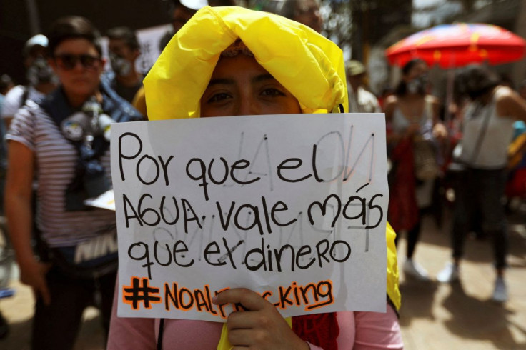A woman holds a sign that reads: "Because water is worth more than money", during a protest against the use of fracking, in Bogota, Colombia June 7, 2019.