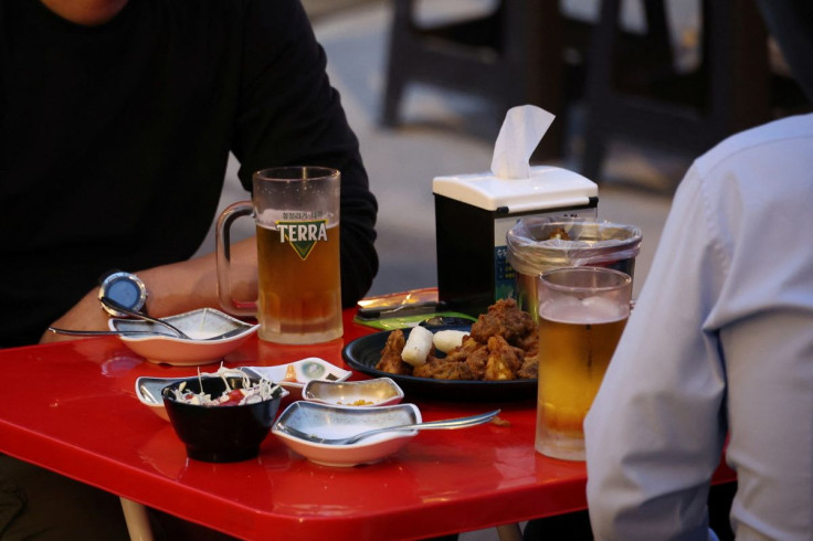 Businessmen enjoy fried chicken and beer at a pub in Seoul, South Korea, April 25, 2022.