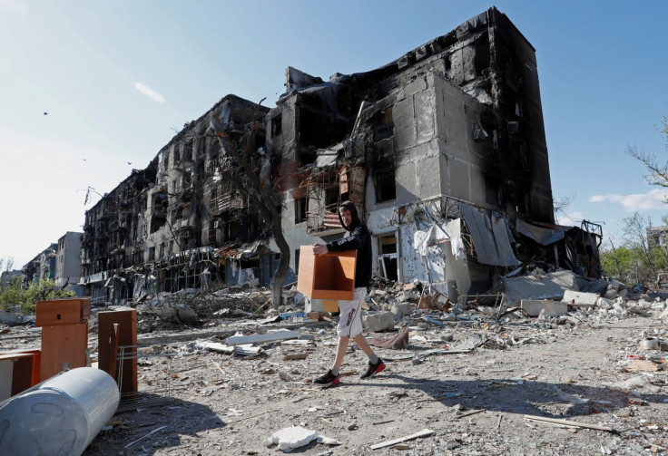A local resident takes furniture out of an apartment building heavily damaged during Ukraine-Russia conflict in the southern port city of Mariupol, Ukraine April 28, 2022. Picture taken April 28, 2022.