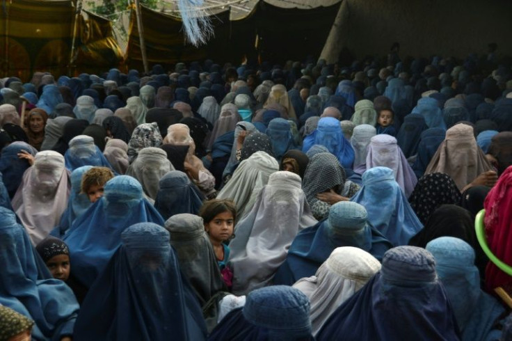 Afghan women and children wait for a food donation ahead of the Eid al-Fitr holiday in Kandahar