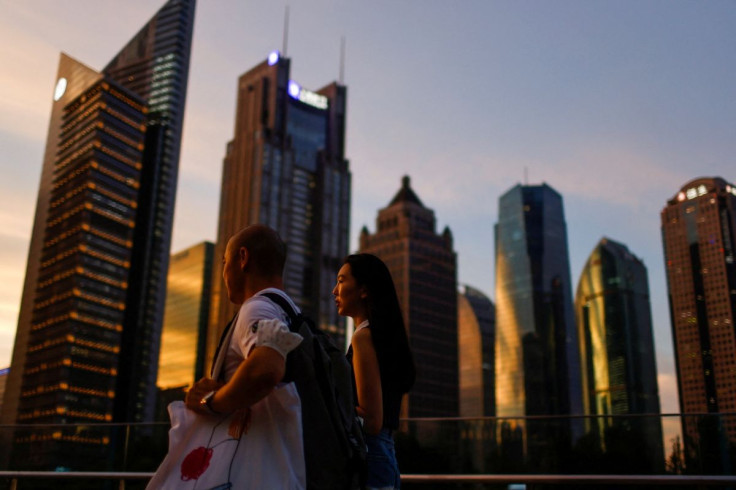 People walk in Lujiazui financial district during sunset in Pudong, Shanghai, China July 13, 2021. Picture taken July 13, 2021.