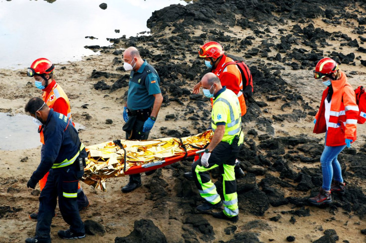 Rescue workers carry the body of a dead person after a boat with 35 migrants from the Maghreb region capsized in the beach of Orzola, in the Canary Island of Lanzarote, Spain, November 25, 2020.