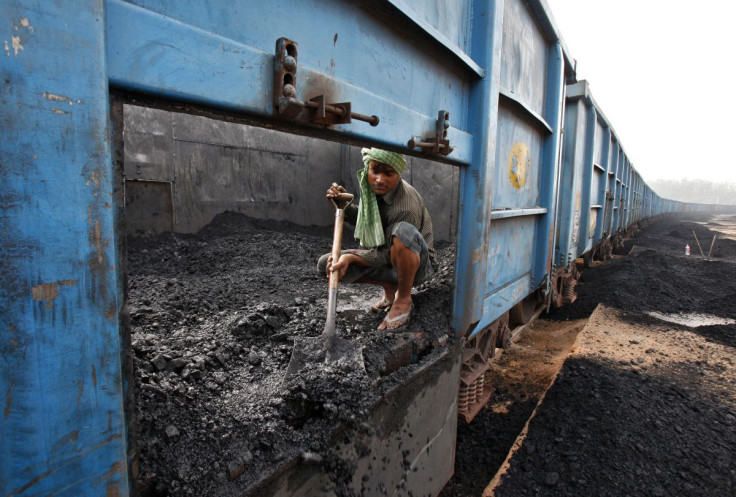A worker unloads coal from a goods train at a railway yard in the northern Indian city of Chandigarh July 8, 2014.