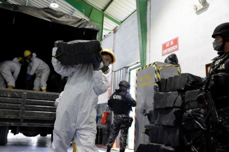Workers unload sacks containing cocaine packages from a truck before the incineration of more than nine tons of cocaine which were seized during different operations, according to the Ecuador's Interior Ministry, in a warehouse at an undisclosed location,