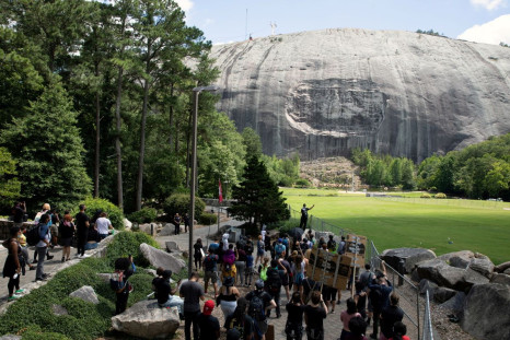 A man speaks into a bullhorn while pointing at the Confederate Monument carved into granite on Stone Mountain while protesting the monument at Stone Mountain Park in Stone Mountain, Georgia, U.S. June 16, 2020. 