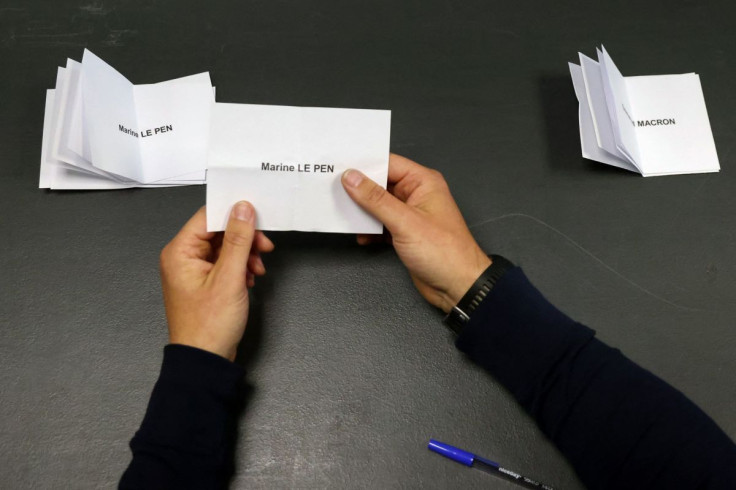 FILE PHOTO - An official stacks ballots for Marine Le Pen, French far-right National Rally (Rassemblement National) party candidate, next to the ballots for French President Emmanuel Macron, candidate for his re-election, during counting of the votes from