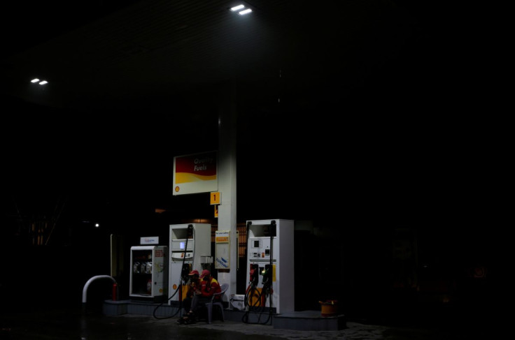 Employees sit next to fuel pumps as they close the petrol station after running out of petrol, in Islamabad, Pakistan July 26, 2017.