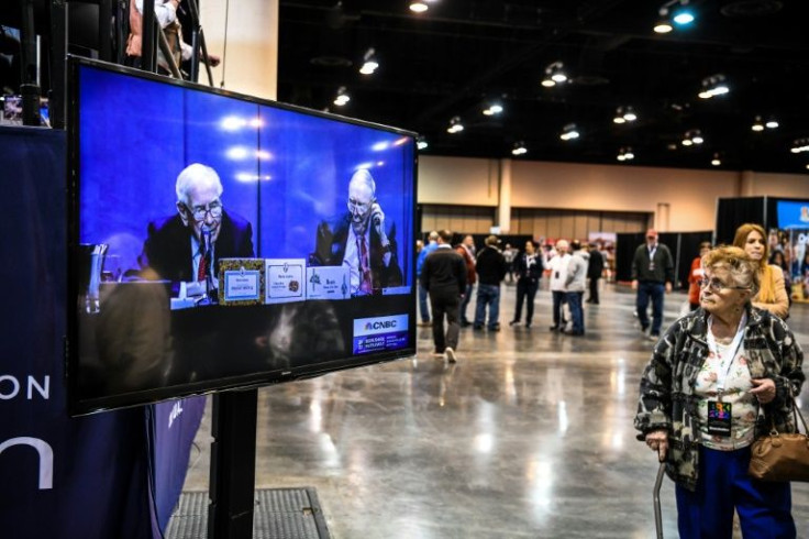 A woman looks at the screen with a live view of Berkshire Hathaway CEO Warren Buffett (L) and Vice Chairman Charlie Munger (R) at the Berkshire Hathaway Shareholders Meeting in Omaha, Nebraska on April 30, 2022.