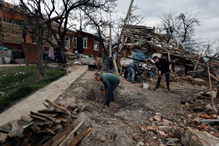 Yevgen Pershukov, 51, and his relative try to clean the house that according to them was destroyed by Russian shelling, amid the invasion of Ukraine, on the outskirts of Chernihiv, Ukraine April 30, 2022. 
