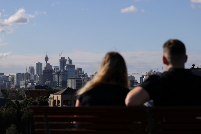 People sitting on a bench at Sydney Park gaze at the city centre skyline amidst the easing of restrictions implemented to curb the spread of the coronavirus disease (COVID-19) in Sydney, Australia, June 26, 2020.  