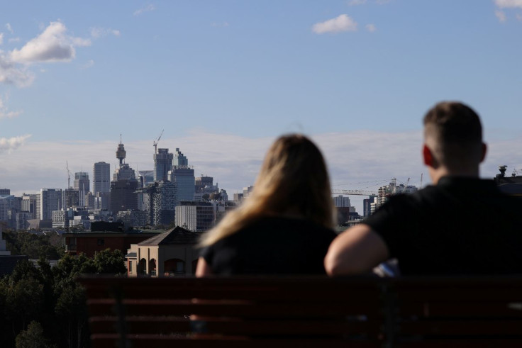 People sitting on a bench at Sydney Park gaze at the city centre skyline amidst the easing of restrictions implemented to curb the spread of the coronavirus disease (COVID-19) in Sydney, Australia, June 26, 2020.
