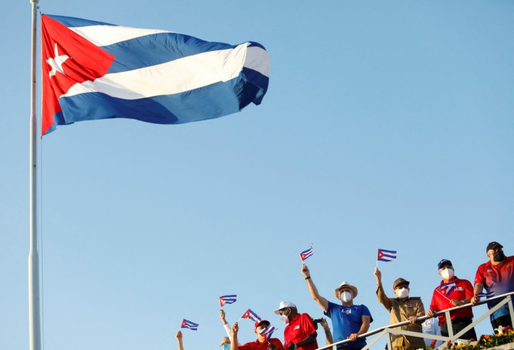 Cuba's President Miguel Diaz-Canel and former President Raul Castro wave national flags as thousands march to Revolution Square to mark May Day, in Havana, Cuba May 1, 2022.