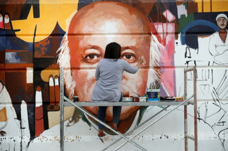Perched on a scaffold at a busy intersection, 49-year-old Wijdan al-Majed adds final touches to a Baghdad mural dedicated to celebrated Iraqi poet Muzzafar al-Nawab