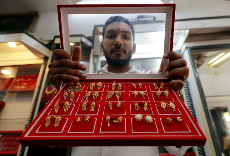 A vendor shows gold stud earrings at a jewellery showroom in Colombo, Sri Lanka, August 11, 2020.