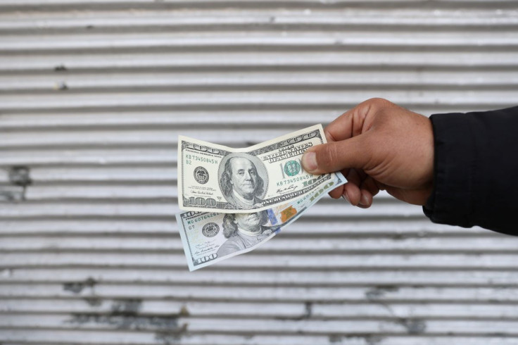A street-side currency vendor holds U.S. dollars at Ferdowsi Square in Tehran, Iran November 14, 2021. Majid Asgaripour/WANA (West Asia News Agency) via 