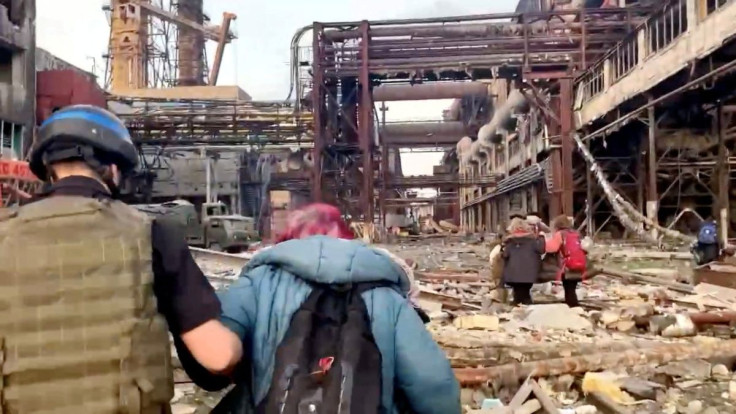Azov regiment members walk with civilians during UN-led evacuations from the sprawling Azovstal steel plant, after nearly two months of siege warfare on the city by Russia during its invasion, in Mariupol, Ukraine in this still image from handout video re