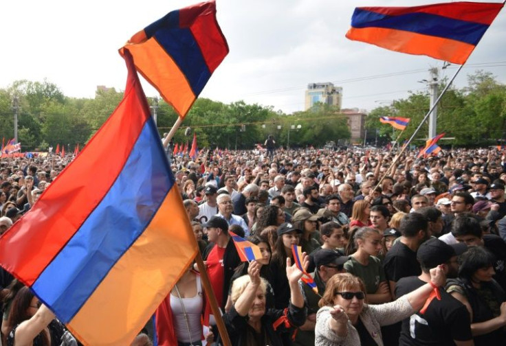 Demonstrators wave national flags as they attend an opposition rally in Yerevan on May 1, 2022