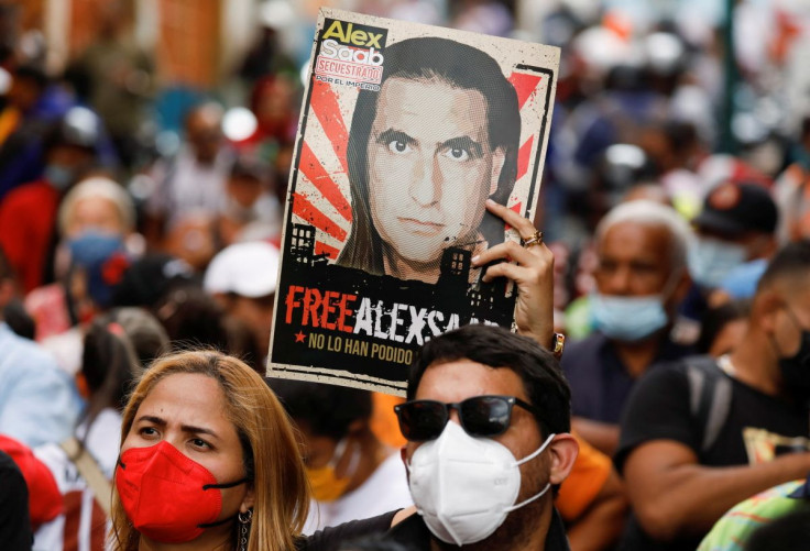 A woman holds a poster with the image of Alex Saab, a Colombian businessman with Venezuelan ties who was extradited to the U.S. on charges of money laundering, during a demonstration calling for his release, in Caracas, Venezuela April 4, 2022.