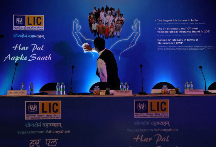A man cleans a hoarding of Life Insurance Corporation of India (LIC) before the start of a news conference about the LIC initial public offering (IPO) launch, in Kolkata, India, April 29, 2022.