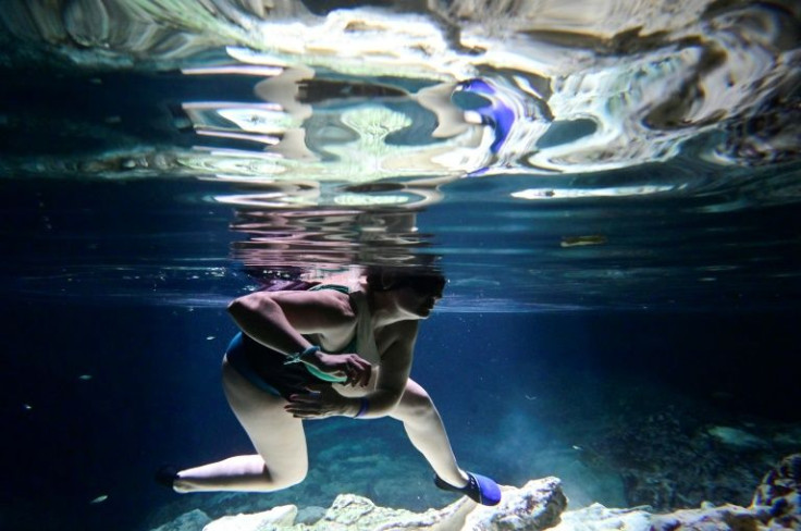 A tourist swims in a sinkhole known as cenote near the construction site of a new Mexican railroad that activists fear will cause irreparable  environmental damage