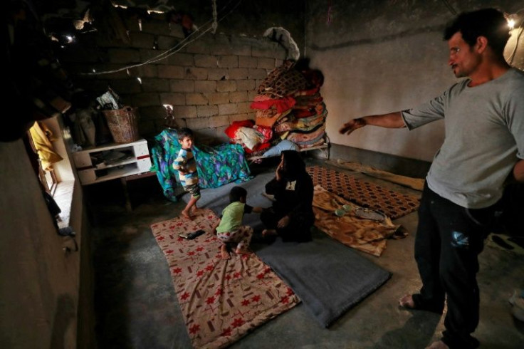 Iraqi father-of-five Issa al-Zamzoum stands inside his damaged house in the war-ravaged village of Habash