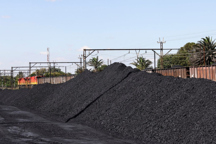 A Transient freight rail train is seen next to tons of coal mined from the nearby Khanye Colliery mine, at the Bronkhorstspruit station, in Bronkhorstspruit, around 90 kilometres north-east of Johannesburg, South Africa, April 26, 2022.