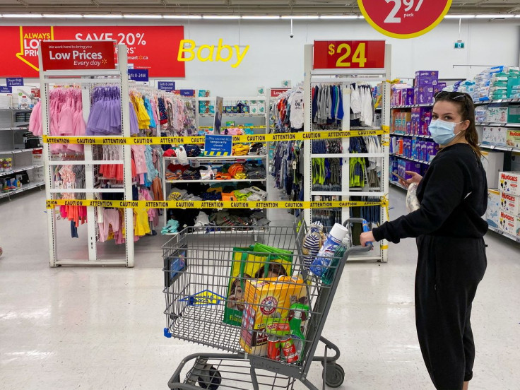 A woman looks on as she walks past cordoned off aisles of non-essential goods at a Walmart store in Toronto, Ontario, Canada April 8, 2021.