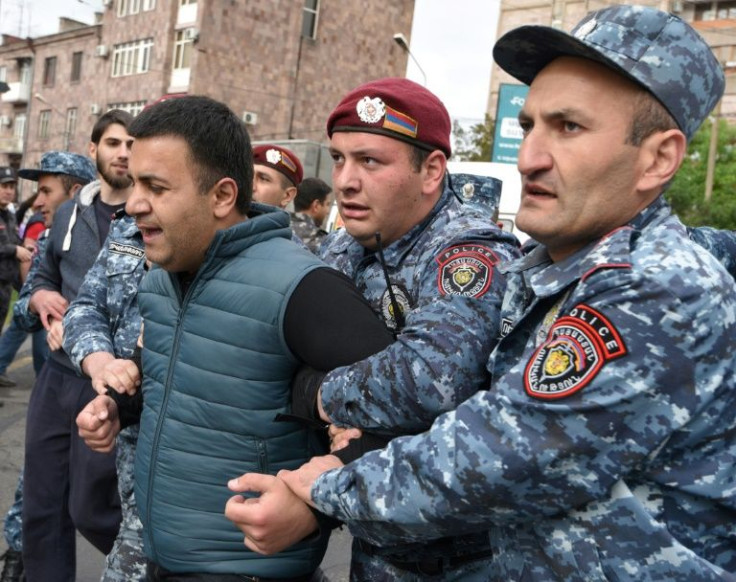 Armenian police officers detain a demonstrator during an opposition rally in Yerevan
