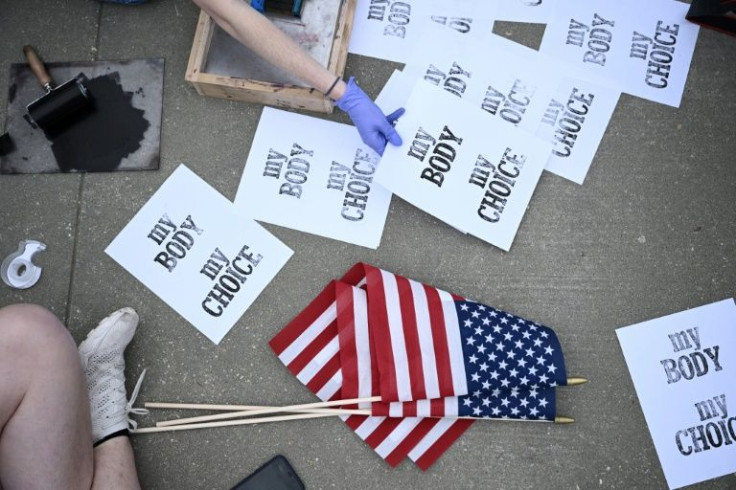A young woman stamped sheets of paper with 'My body, my choice,' before hanging them from a fence in front of the US Supreme Court taped to wire hangers -- in reference to dangerous methods once used in illegal abortions