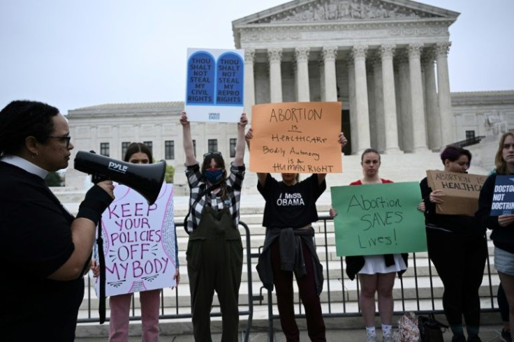 Demonstrators for abortion rights hold signs in front of the US Supreme Court in Washington protesting a draft ruling that would strike down the nationwide right to abortion