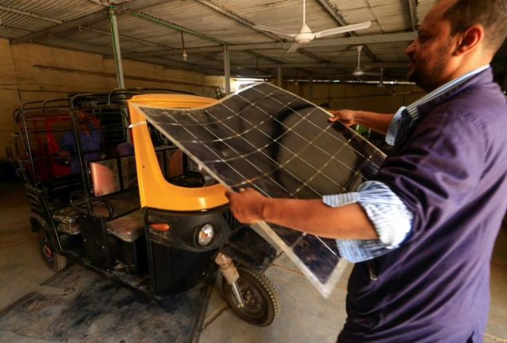 Workers assemble electric tuk-tuks in Khartoum: the three-wheelers take about eight hours to be fully charged