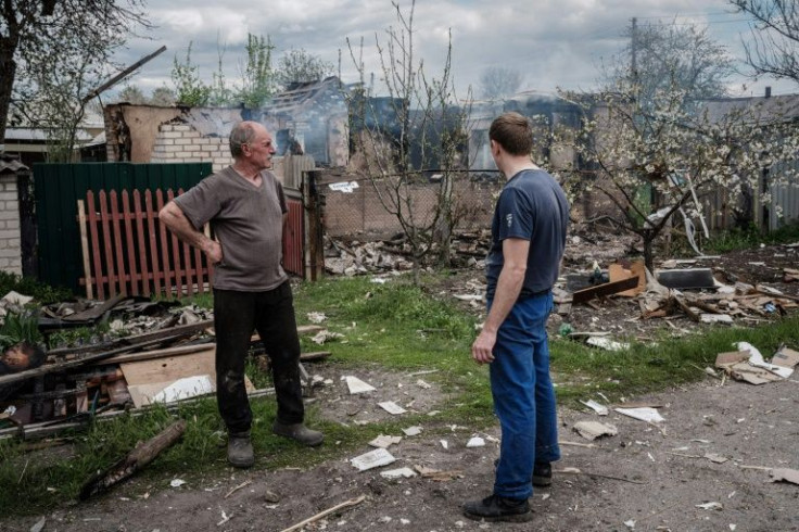 Oleksii Krylovskii (R), 34, and his father Volodymyr Krylovskii, 62, look at the remains of their house in the city of Lyman, destroyed by shelling